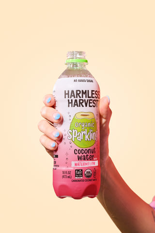 harmless harvest watermelon sparkling coconut water being held in hand