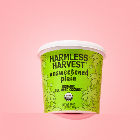 harmless harvest dairy-free yogurt alternative in front of pink background